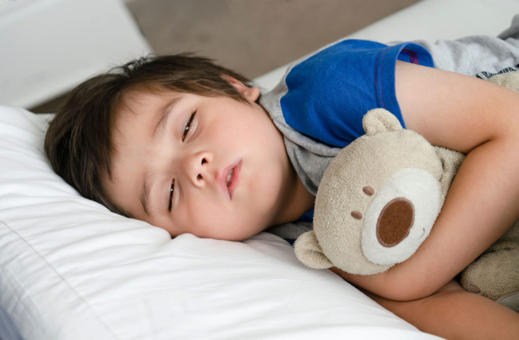 A little boy sleeping with his eyes half open can cause a dry eyes.