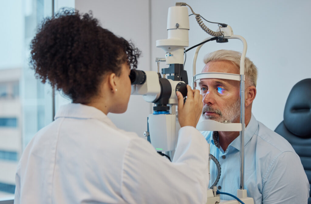 A female optometrist performs an eye exam on a senior male patient