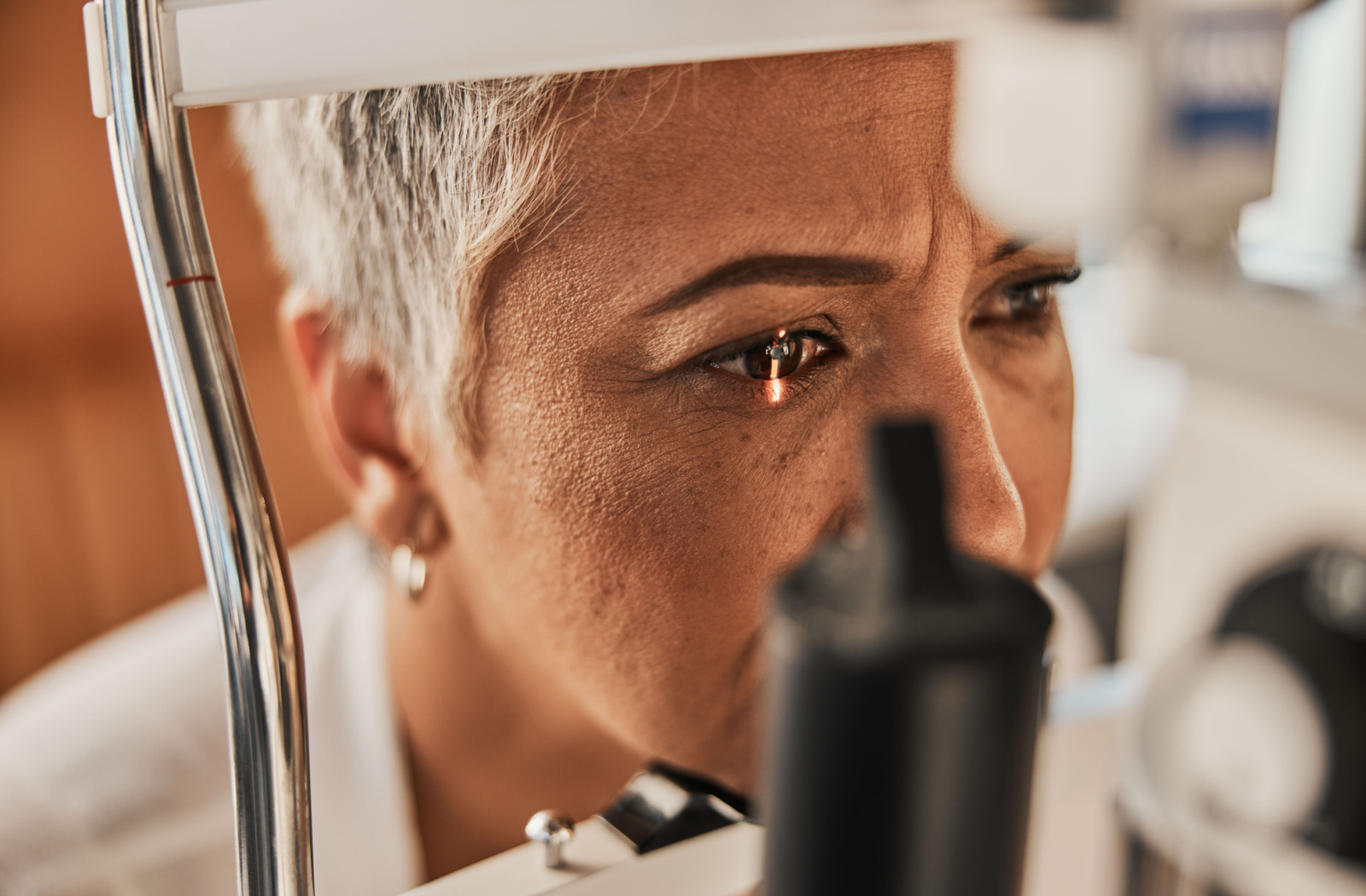 Close up of a senior woman undergoing a slit lamp examination at an optometrist's practice.