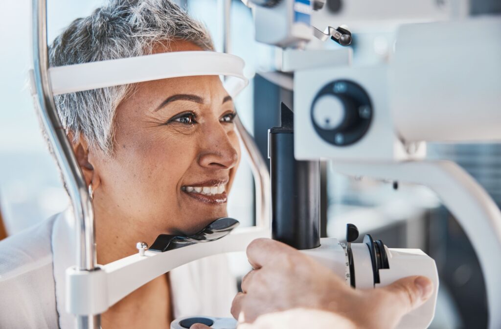 A senior woman smiling at her optometrist during a comprehensive eye exam.