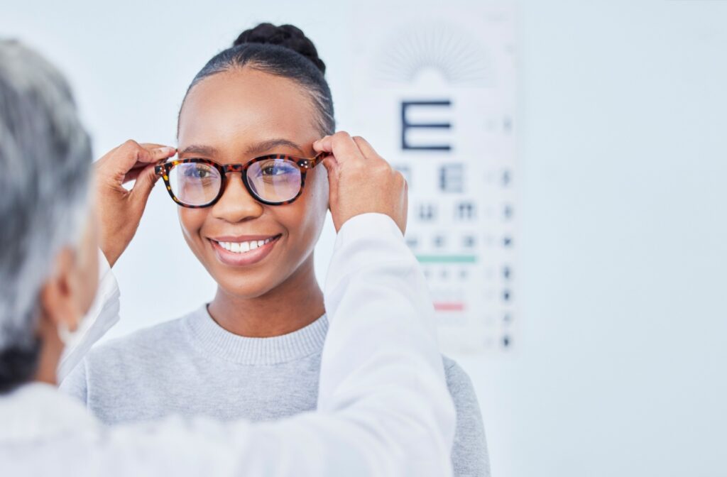 A woman getting assessed for a new pair of prescription glasses. The optometrist is testing the fit of her glasses.