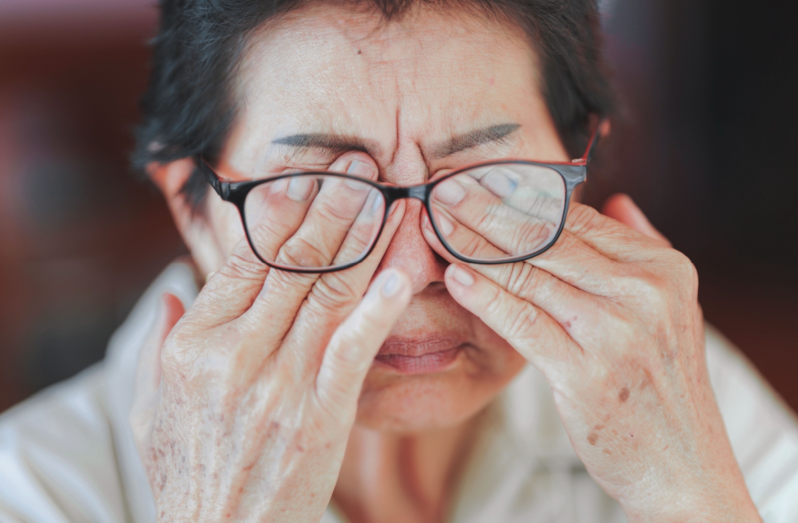 A person rubbing their dry eyes as they try to deal with symptoms of irritation.
