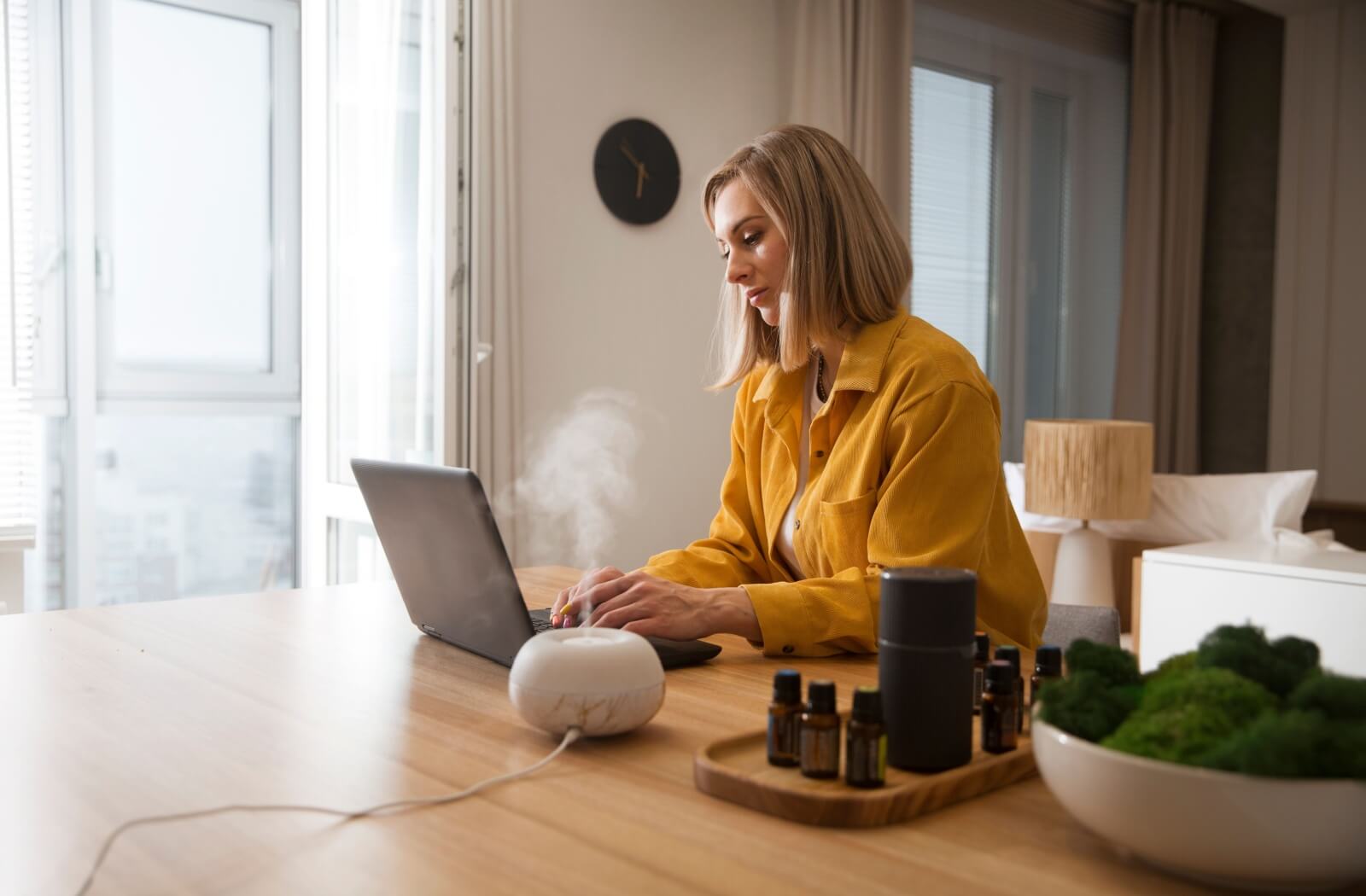 A person working at their computer with a humidifier nearby to keep moisture in the air, and reduce eye strain