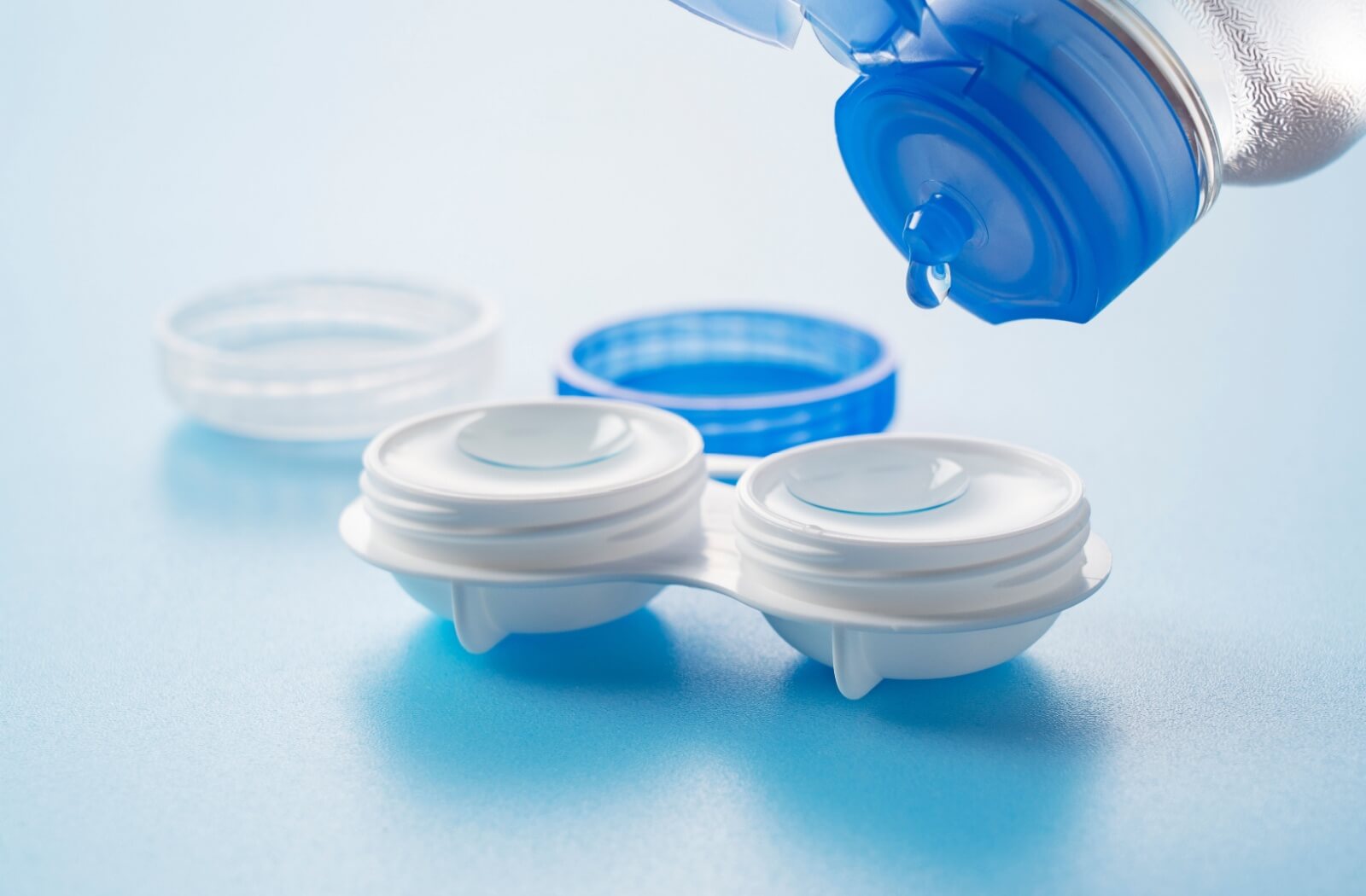 Contact lens solutions being added to contacts in a container