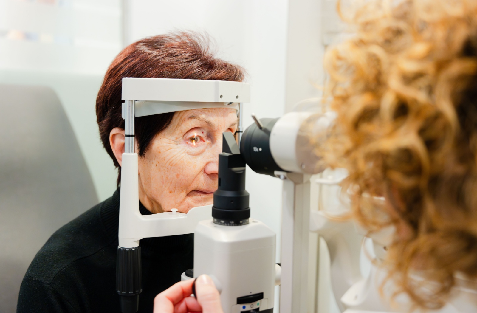 An older adult gets an eye exam so their eye doctor can look for signs of cataracts.